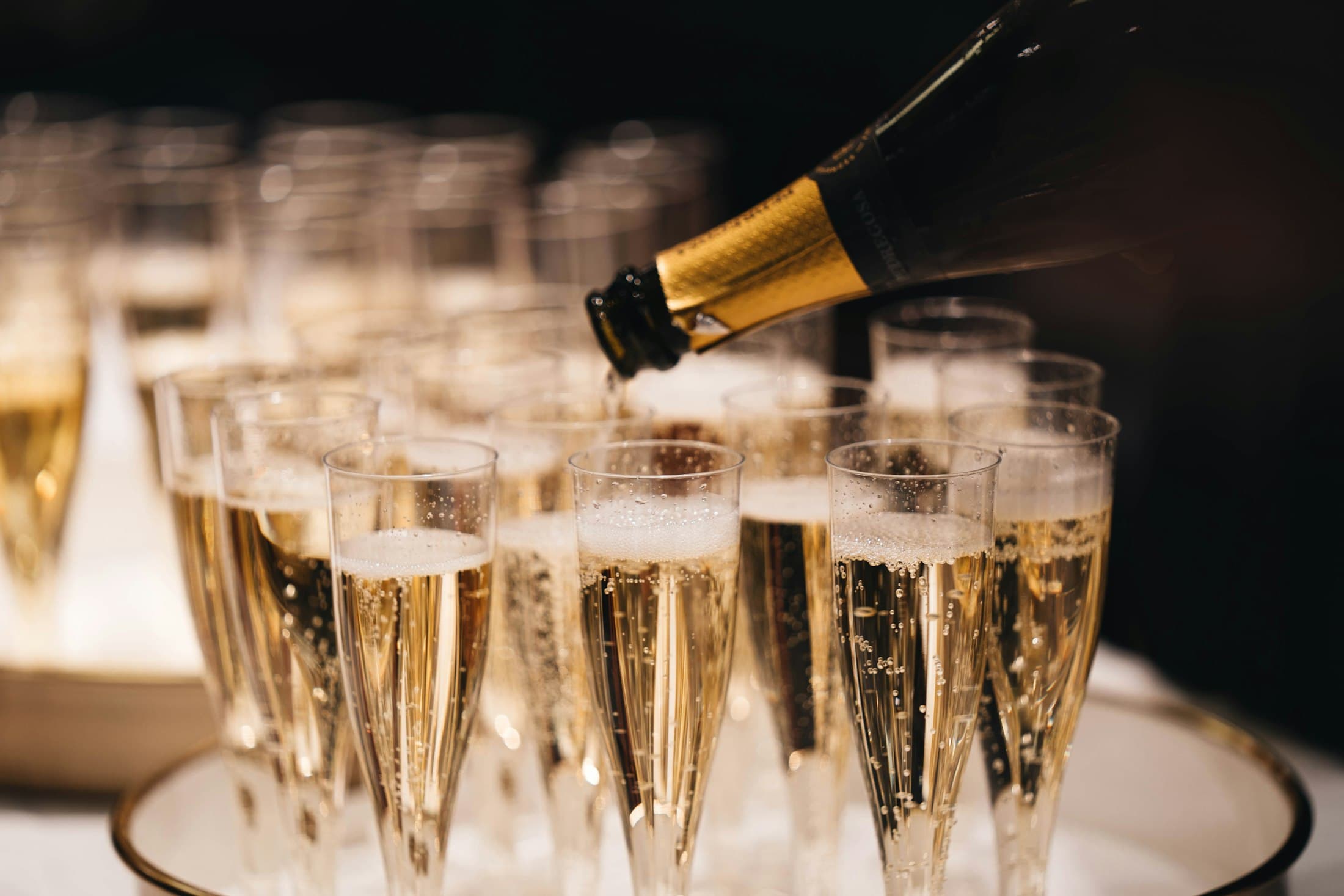Champagner wird in eine Pyramide aus Gläsern gegossen