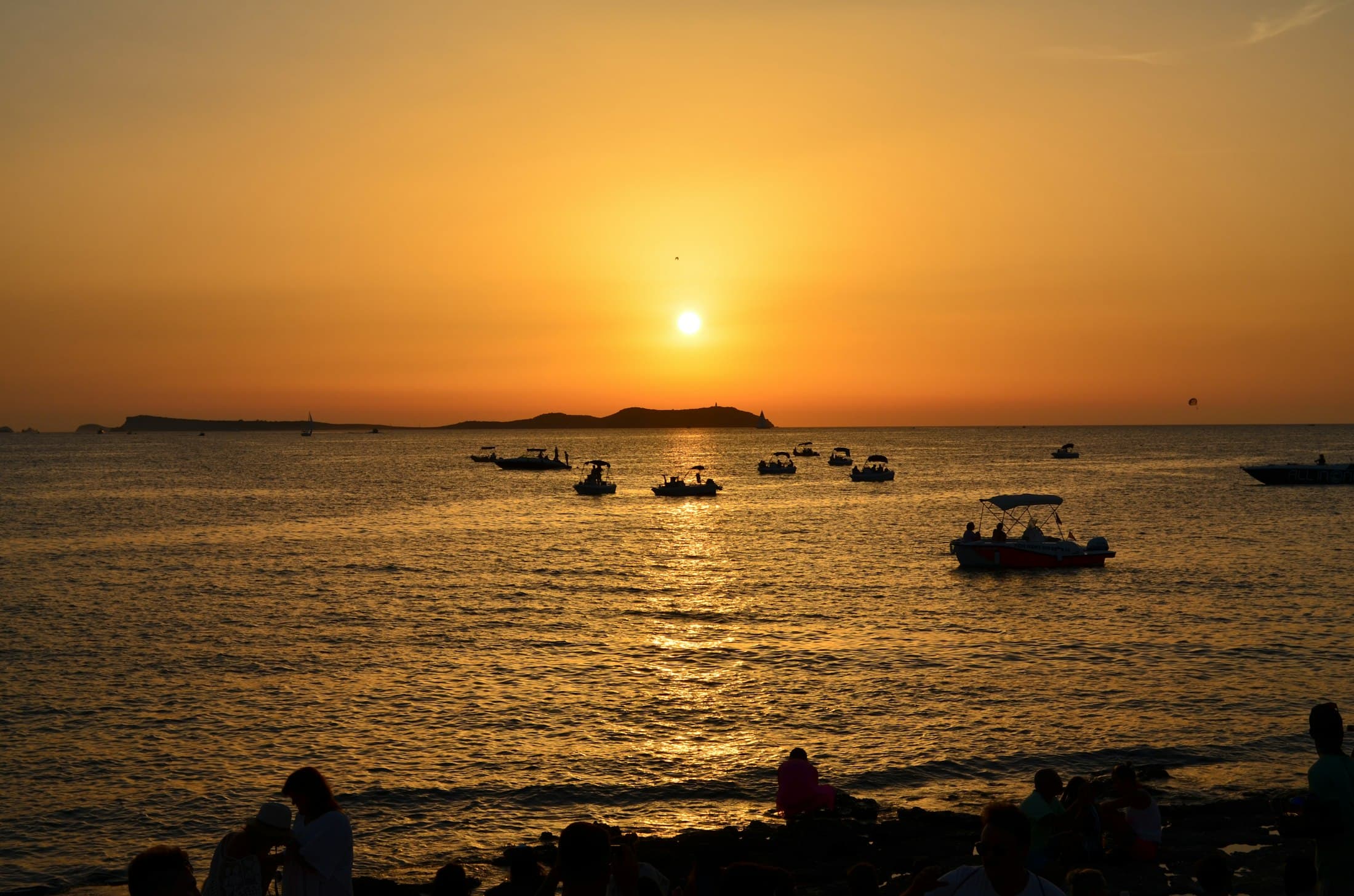 Sonnenuntergang über einer Bucht auf Ibiza mit Booten
